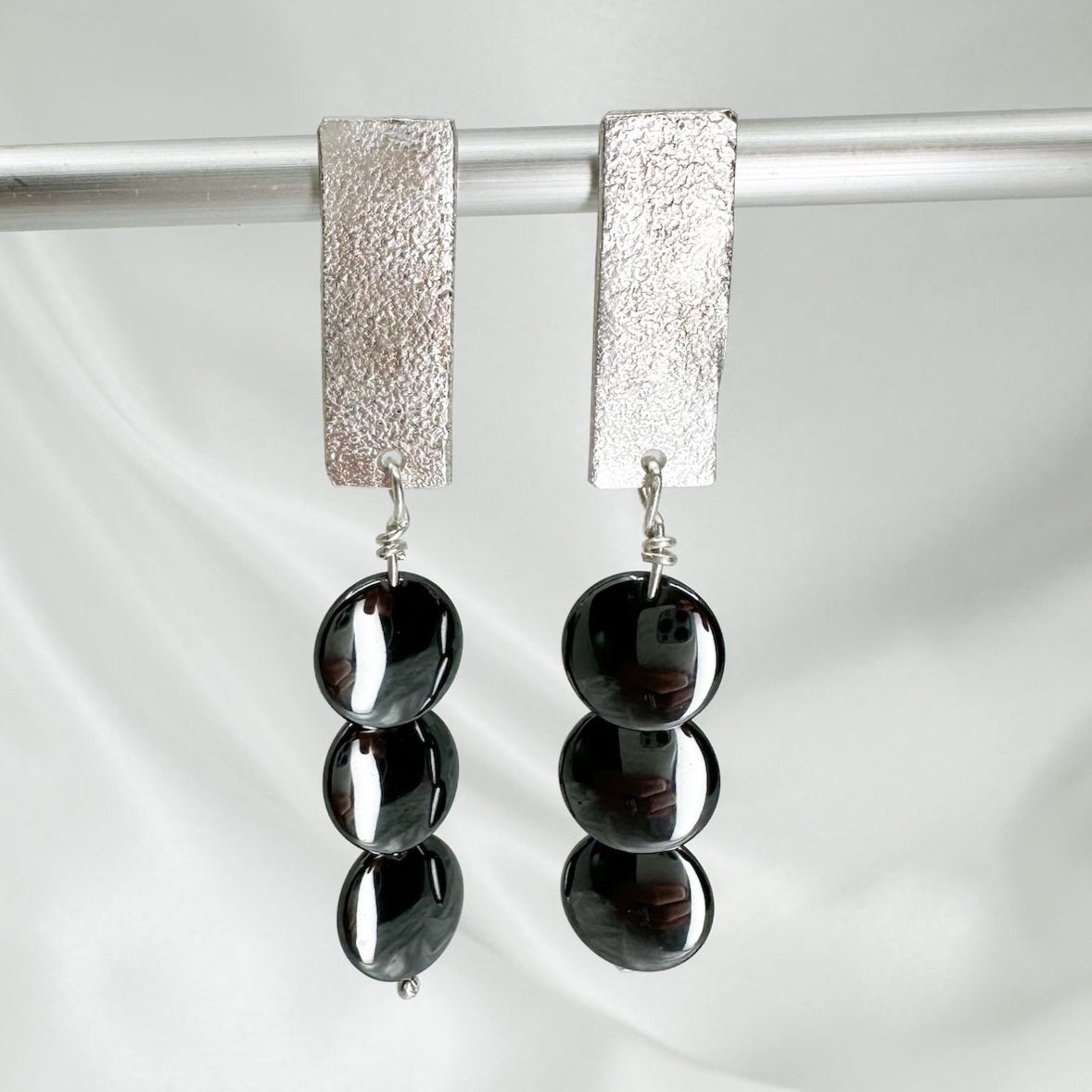 Handmade sterling silver hematite drop earrings with minimalist sculptural design.
