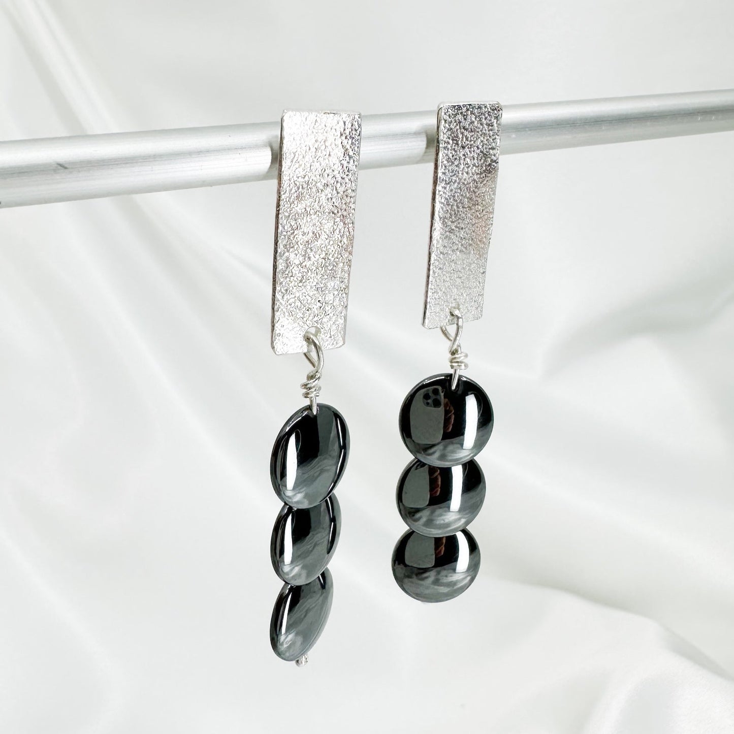 Handmade sterling silver hematite drop earrings with minimalist sculptural design.