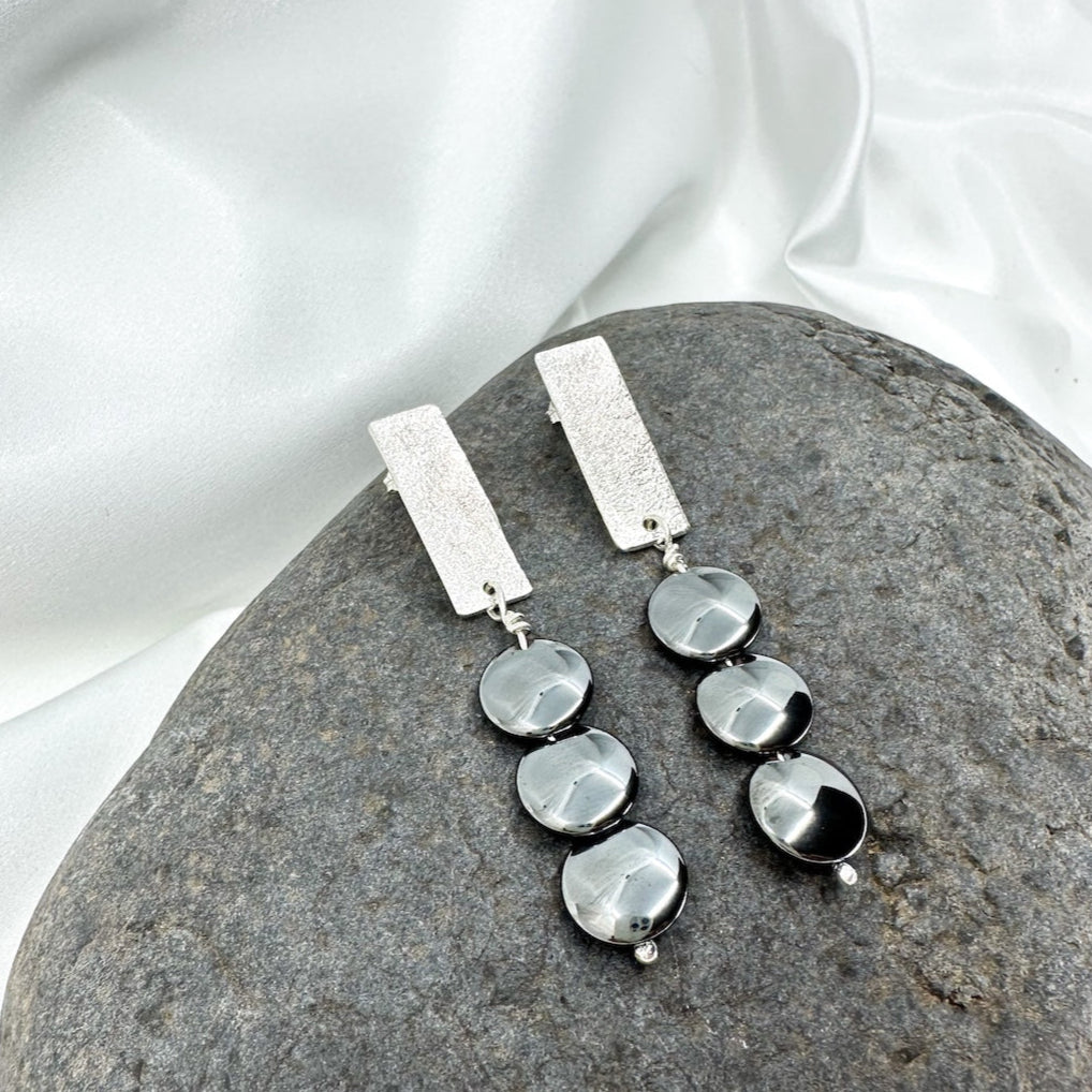 Handmade sterling silver hematite drop earrings with minimalist sculptural design.