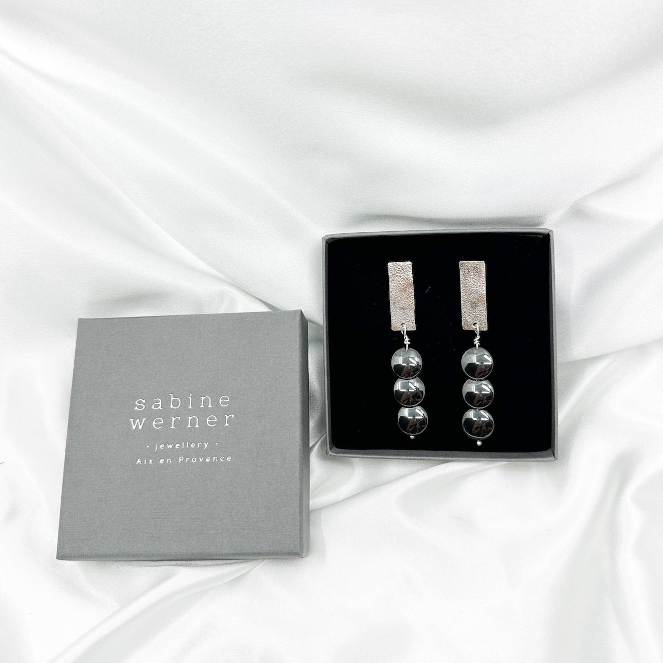 Handmade sterling silver hematite drop earrings with minimalist sculptural design.boxed