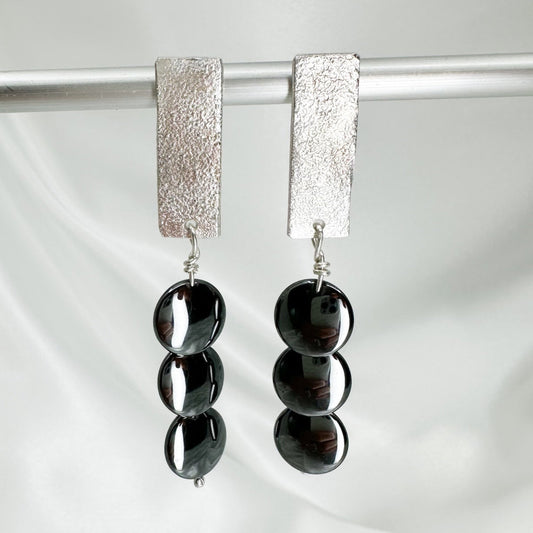Handmade sterling silver hematite drop earrings with minimalist sculptural design.