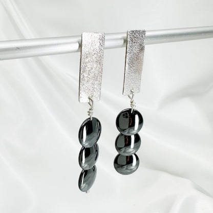 Handmade sterling silver hematite drop earrings with minimalist sculptural design.