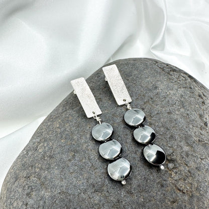 Handmade sterling silver hematite drop earrings with minimalist sculptural design.