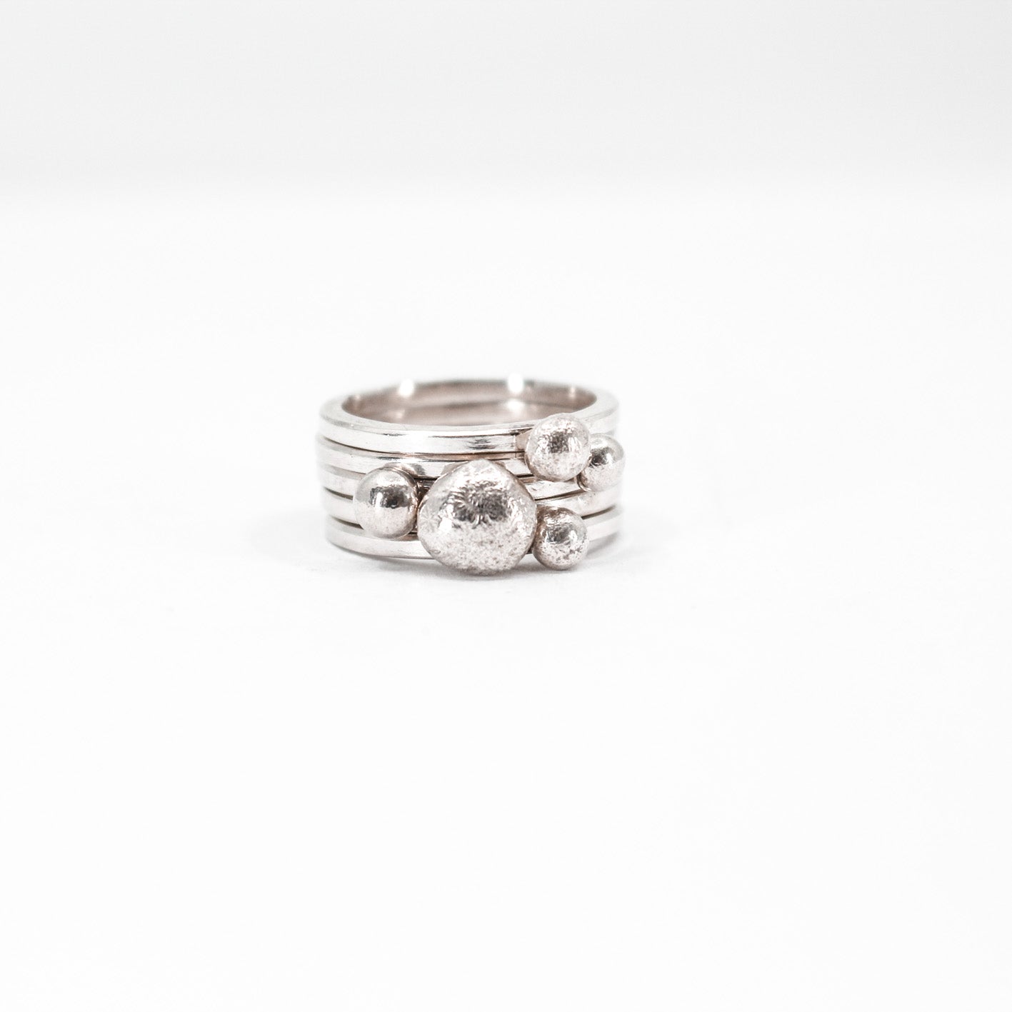 five simple silver stacking rings each with a textured sterling silver drop, sabine Werner jewellery 