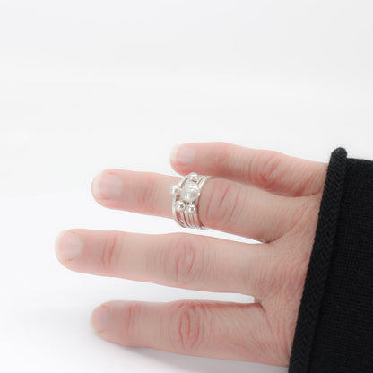 five simple silver stacking rings each with a textured sterling silver drop