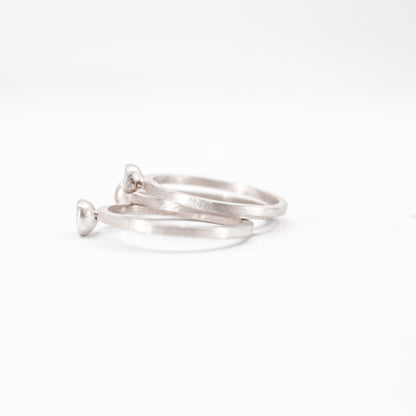 three simple silver stacking rings with each a set black diamond