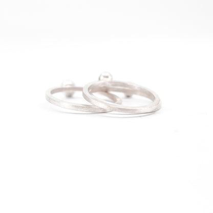 three simple silver stacking rings with each a set black diamond