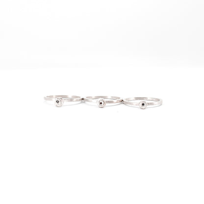 three simple silver stacking rings with each a set black diamond