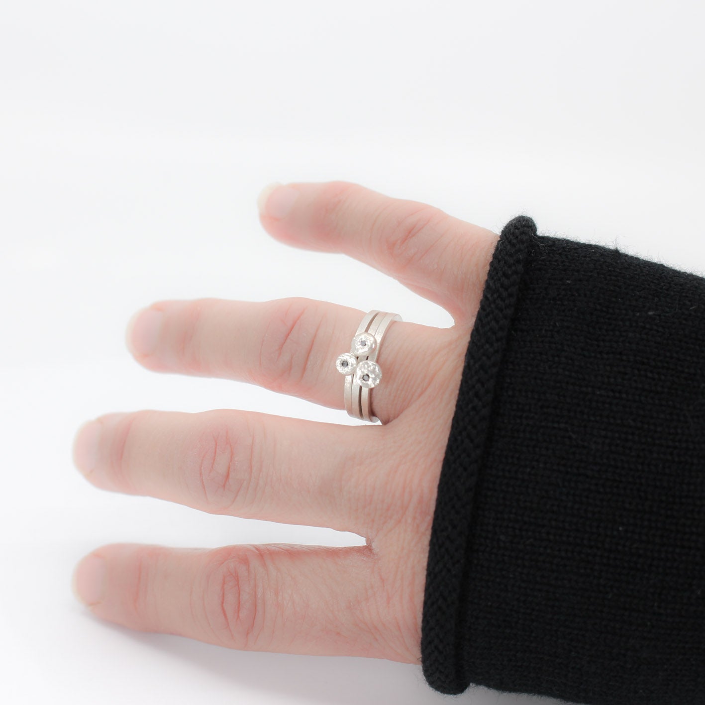 three simple silver stacking rings with each a set black diamond